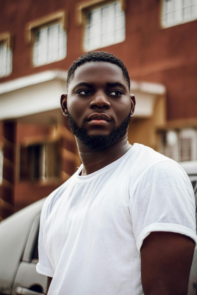 Home Portrait of a bearded man in white shirt against urban Lagos backdrop.